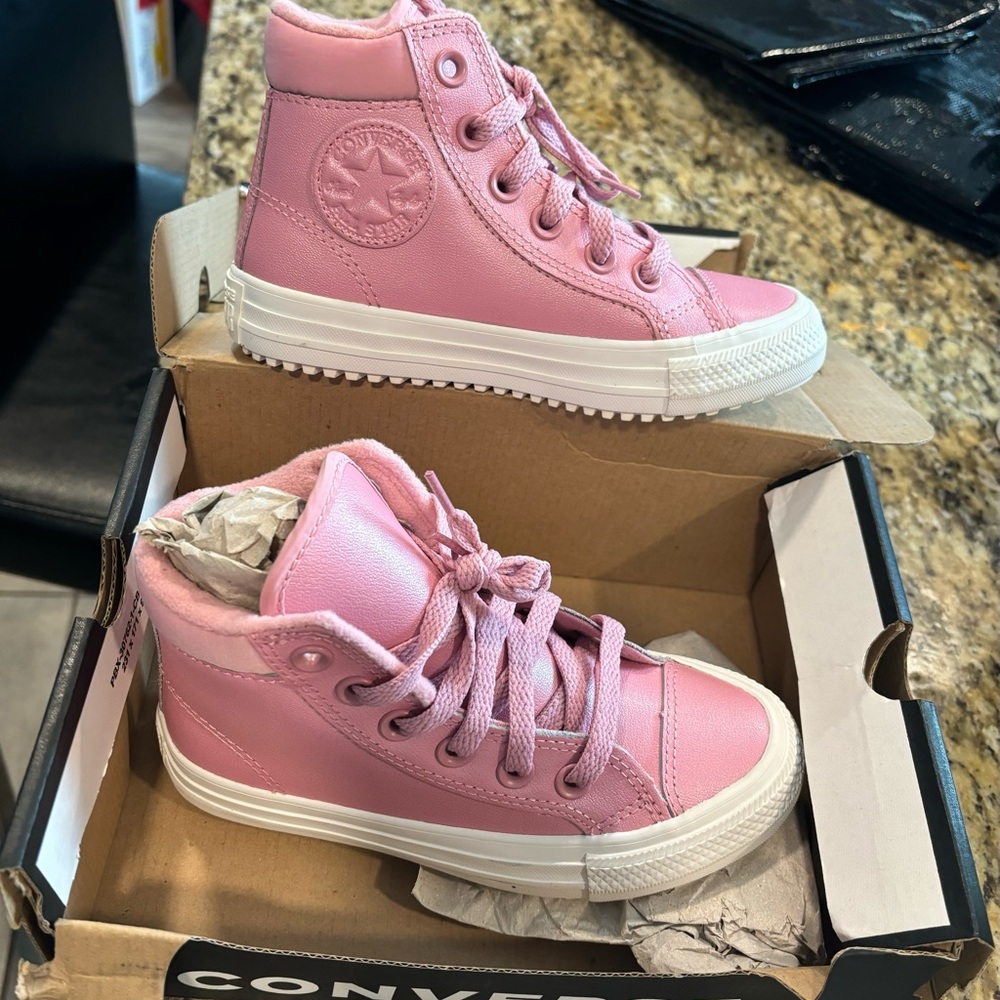 Pink high top Converse with fuzzy ankle interior.